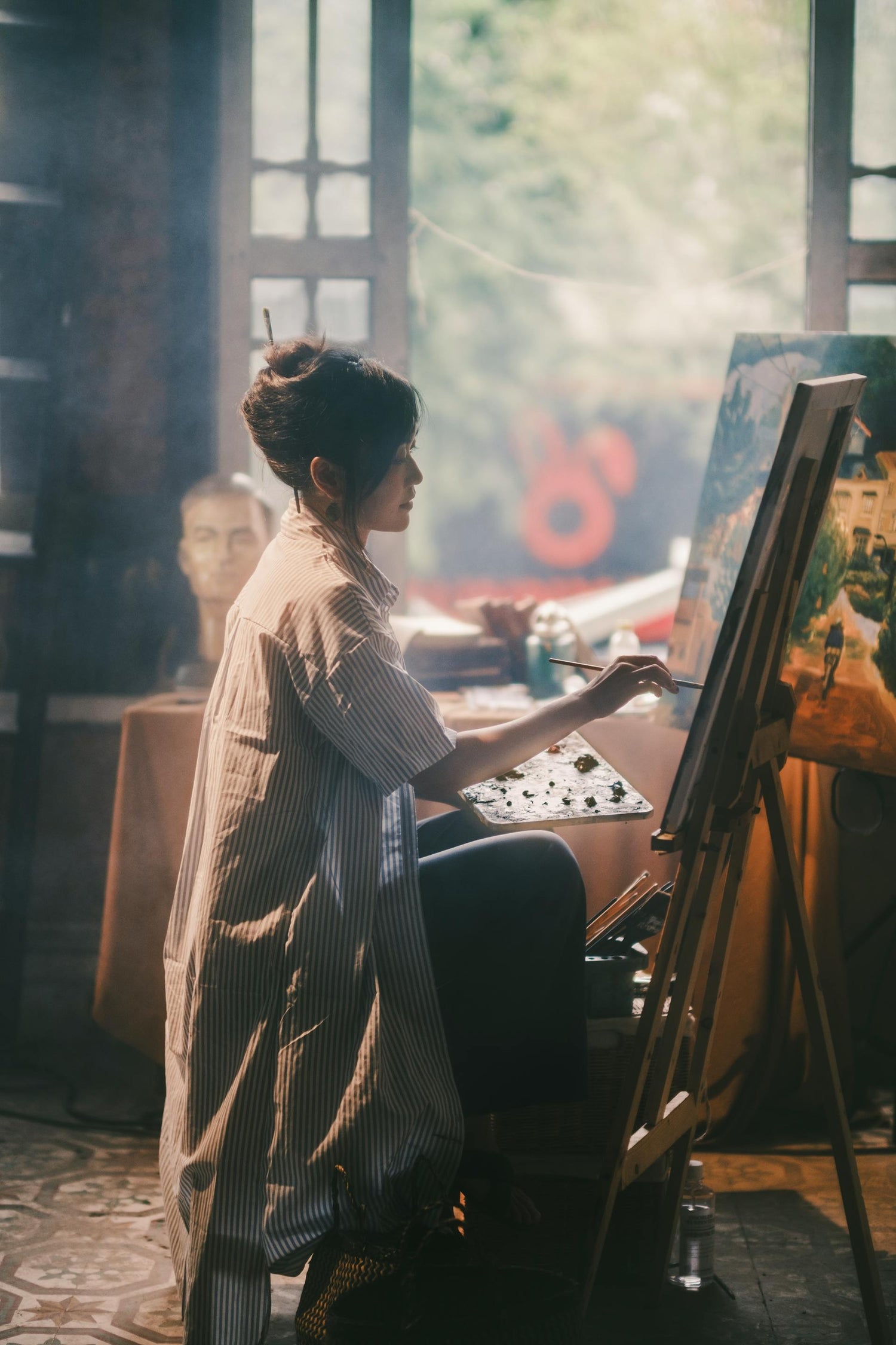 "Artist painting in a studio with natural light using eco-friendly materials from P9. eco-friendly artist materials, vegan oil paints, non-toxic art supplies